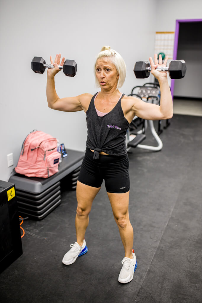 woman lifting weights at perfect fitness